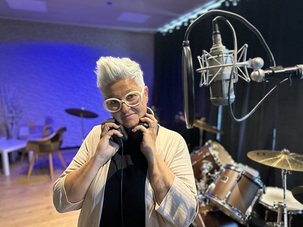 Chris Lirussi in sala prove con le cuffie, accanto al microfono